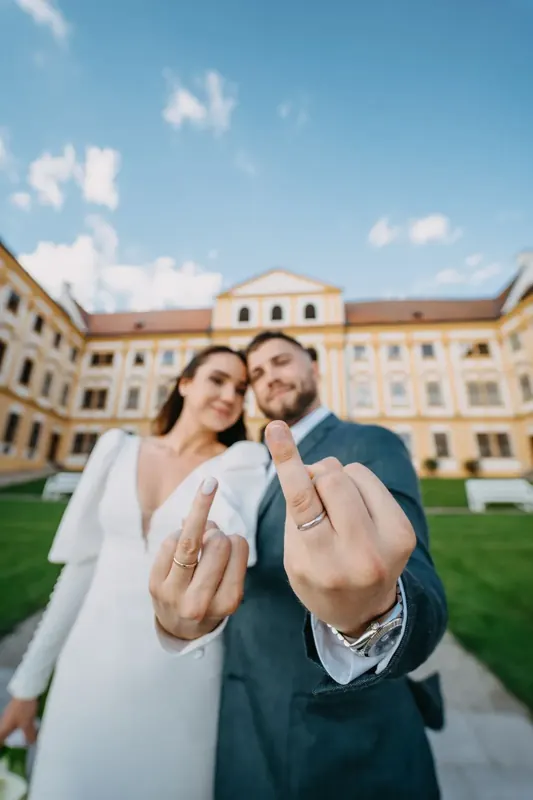 Novomanželé ukazují snubní prstýnky